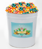 Load image into Gallery viewer, Large Easter Basket tin filled with Rainbow popcorn in Blue Raspberry, Grape, Vanilla, Lemon and Orange.
