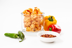 Load image into Gallery viewer, Hot &amp; Spicy Gourmet Popcorn displayed with fresh jalapenos, spicy red pepper seasoning and bright red and yellow peppers.
